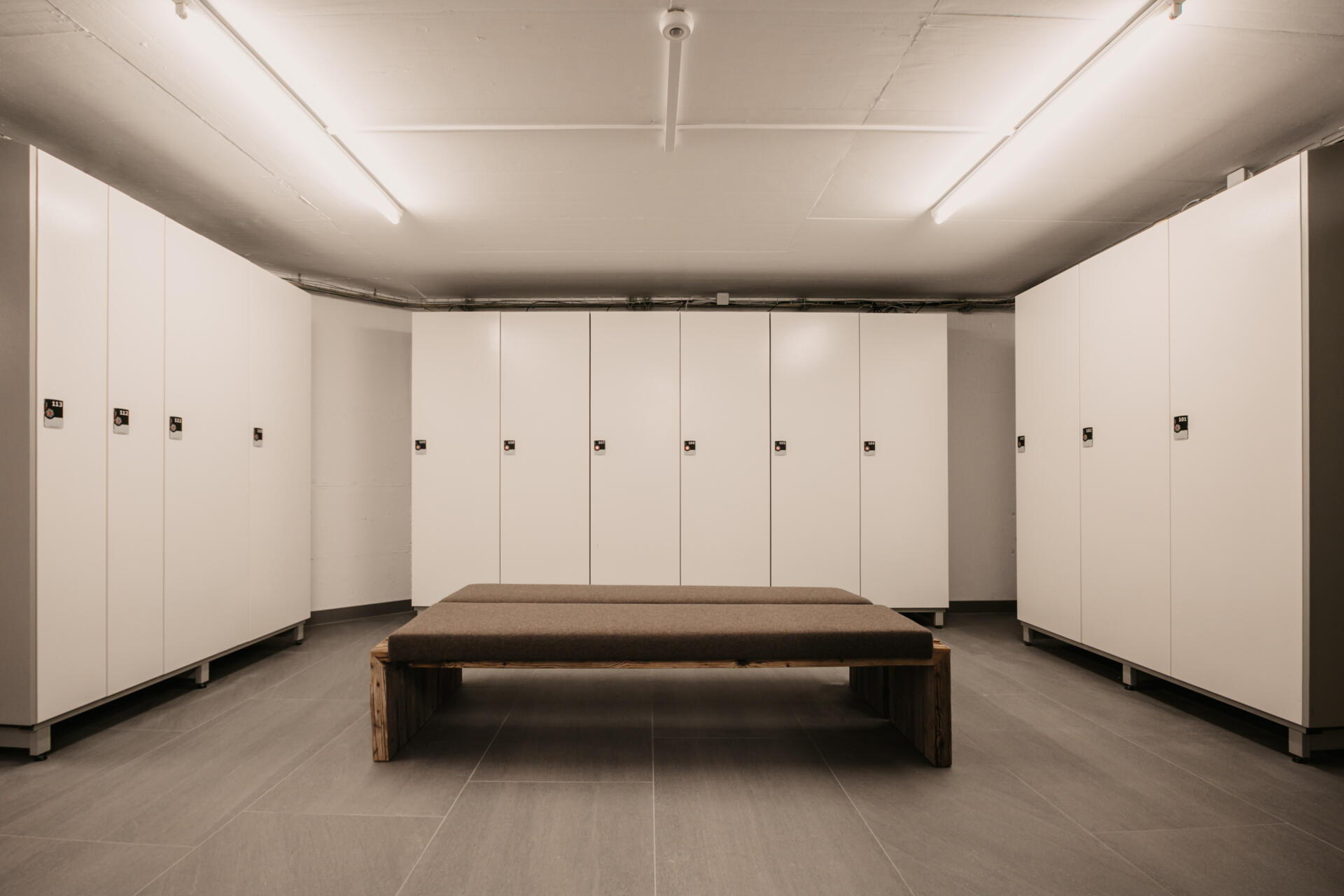 Room with ski lockers and a bench in the middle