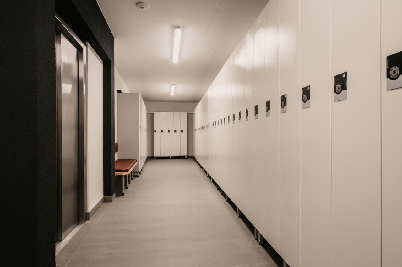 Ski storage room with a row of bright ski lockers