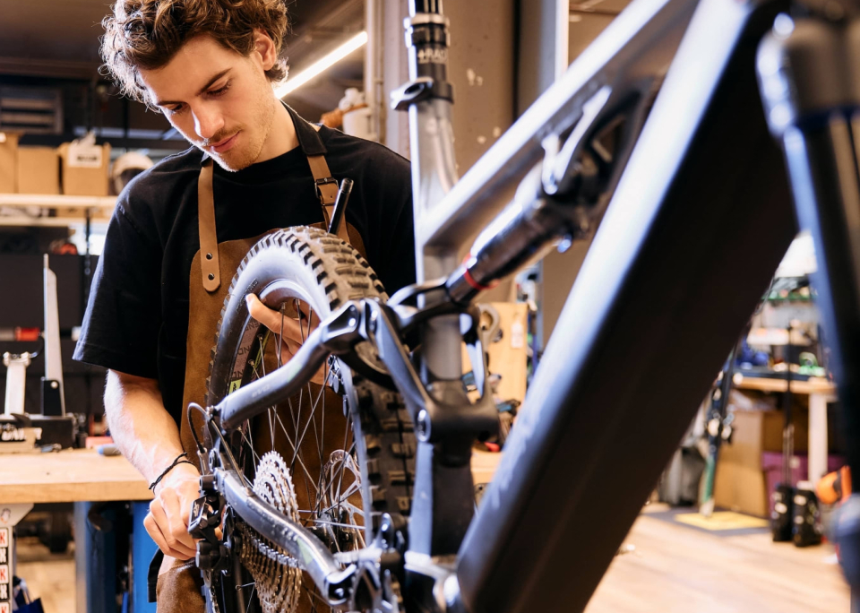 Mann schraubt in der Werkstatt an einem Bike